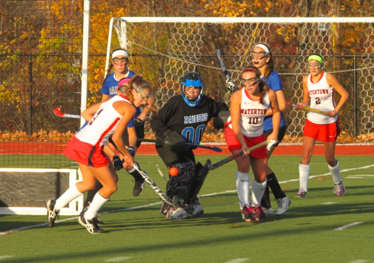 Watertown's Mikayla Paone, left, and Sydney Poulin fight for the ball in front of the Dover-Sherborn goal in Tuesday's state semifinal. 