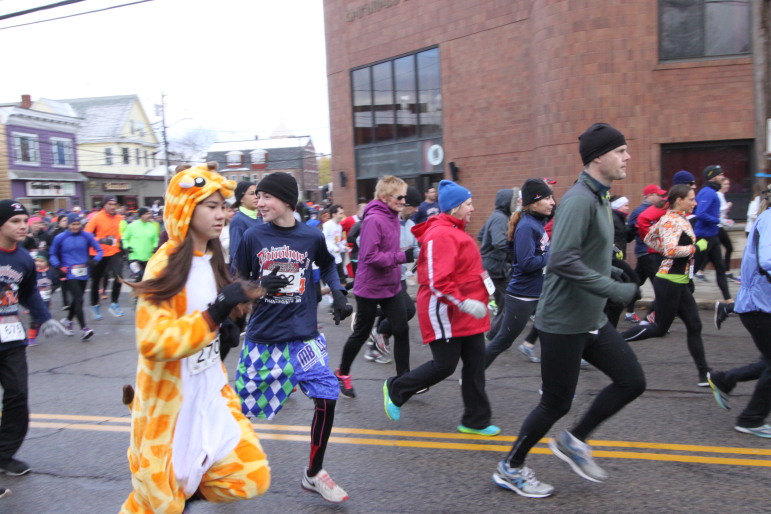 Runners take off at the start of the Donohue's Turkey Trot, including a woman dressed as a giraffe.