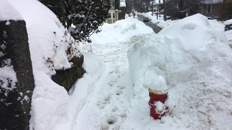 A cleared walking path in Watertown ends abruptly because a neighboring property has not cleared its sidewalk.