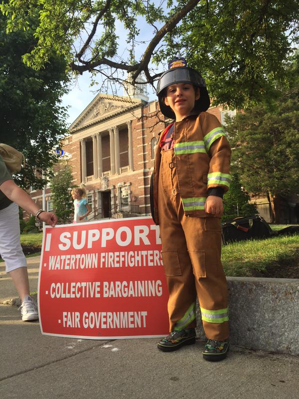 Six-year-old Basil shows his support for the Watertown Firefighters in their contact dispute.