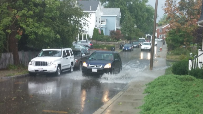 A car drives through flooded streets near Watertown Square after a violent storm on Aug. 4.