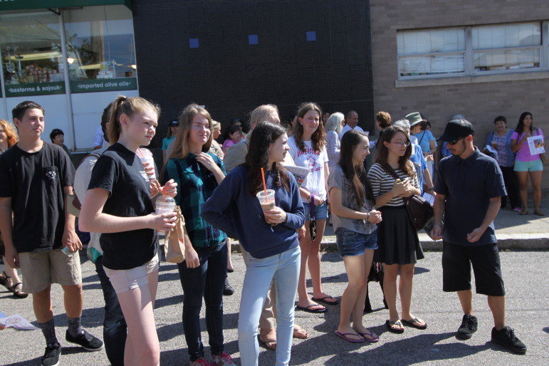 Watertown High School students chat with artist and mentor Gregg Bernstein during the celebration of the new mural they painted in Coolidge Square