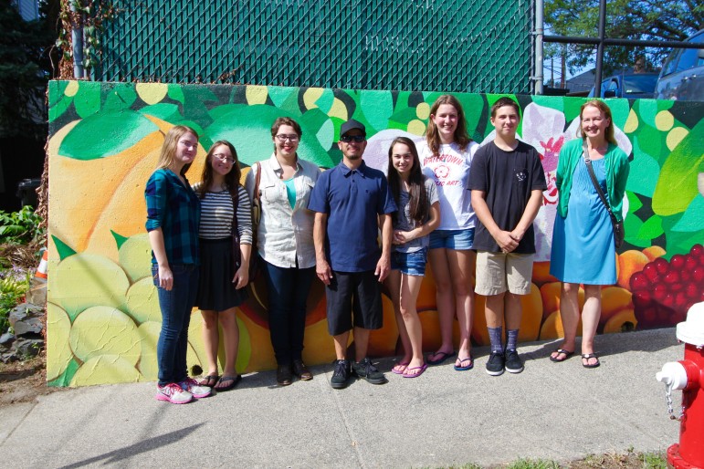Some of the student artists who painted the mural "Seeds of Change" in East Watertown, with artist Gregg Bernstein, center, and Watertown High School art teacher Donna Calleja.