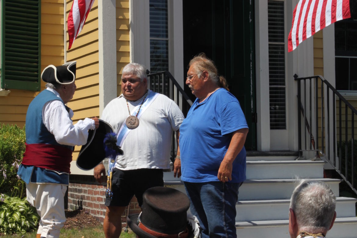 Jack Piantedosi (left) presents Ron Knockwood (center) with a colonel's tricorner hat. Knockwood is a district chief of the Mi'kmaq Indians in Nova Scotia.