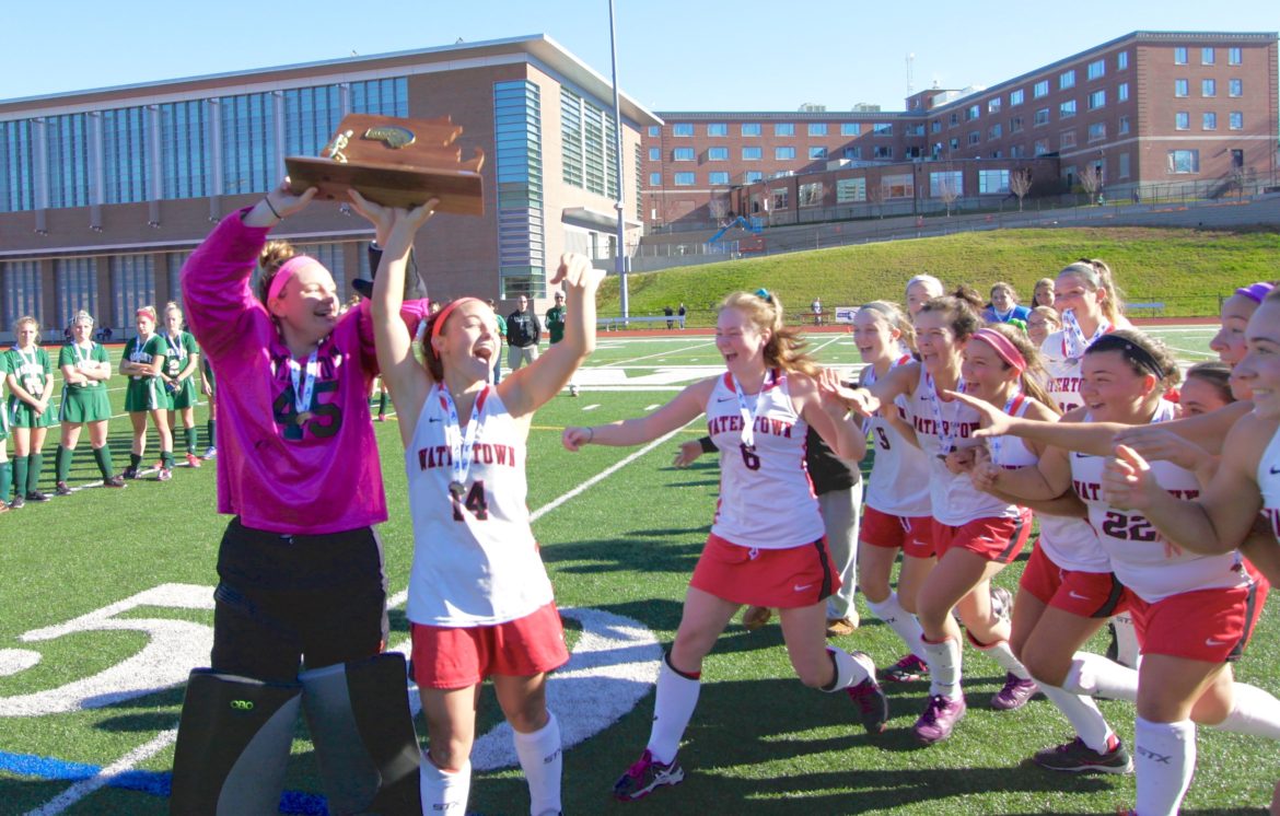 The Watertown field hockey team rushes to celebrate with co-captains and sisters junior Jonna Kennedy, left, and senior Kourtney Kennedy. The Raiders won their eighth straight Div. 2 State Championship.