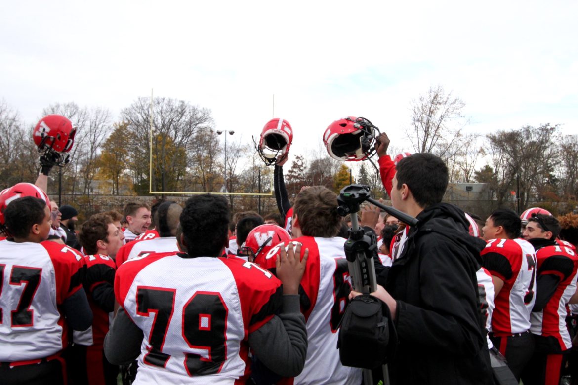 The Raiders celebrate after learning they had won the Middlesex League Freedom Division title following the Thanksgiving Day game.